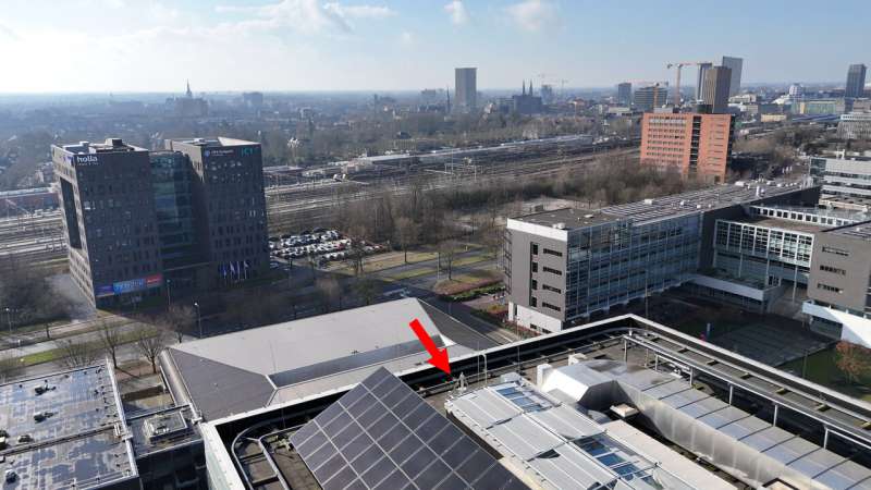 A drone shot of the optical antenna on the Flux roof, facing in a south-southwesterly direction. The antenna is visible to the right of the solar panels in the foreground. Credit: Alireza Hajiarab Derkani Invisible beams of light above Eindhoven provide super-fast wireless data transfer