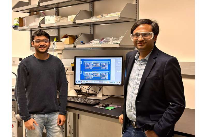 Subir Ghosh, left, and Saptarshi Das, right, led a team in developing a silicon-free, complementary metal-oxide-semiconductor computer capable of simple operations. Displayed between them is an microscope image of the fabricated computer. Credit: Penn State World's first non-silicon 2D computer developed